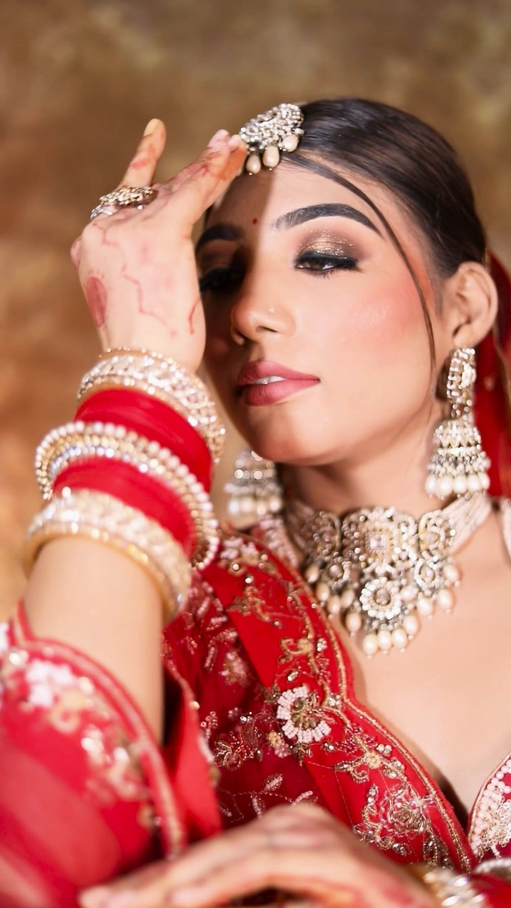 Bridal portrait with red chooda, smokey eyes and kundan jewellery